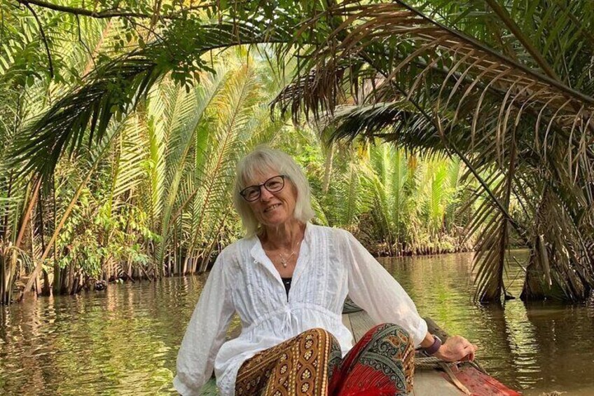 A person sitting on a boat in a mangrove forest. 4