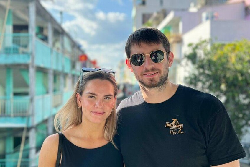 A man and a woman standing outdoors with buildings in the background. 4