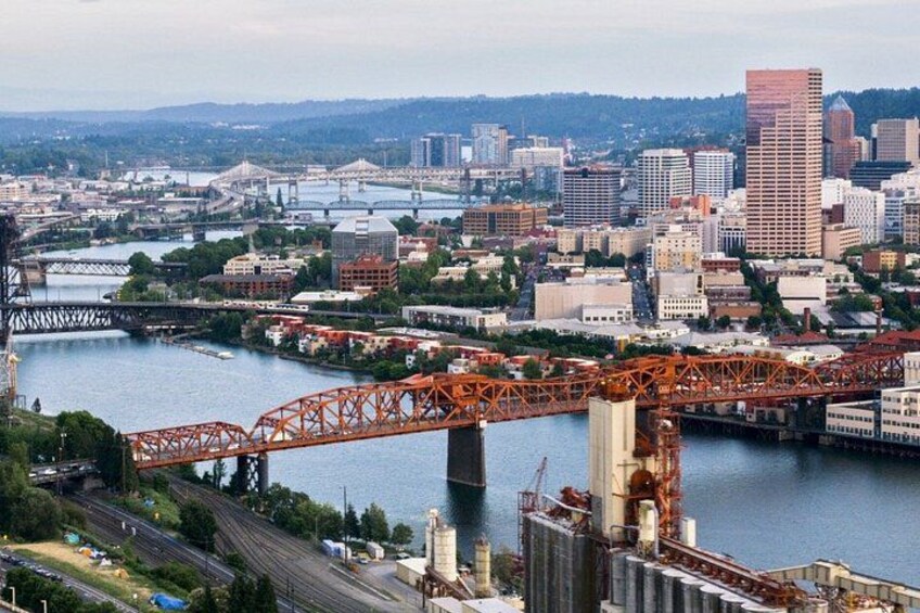 A cityscape with a prominent bridge spanning a river, surrounded by urban buildings and infrastructure. 3