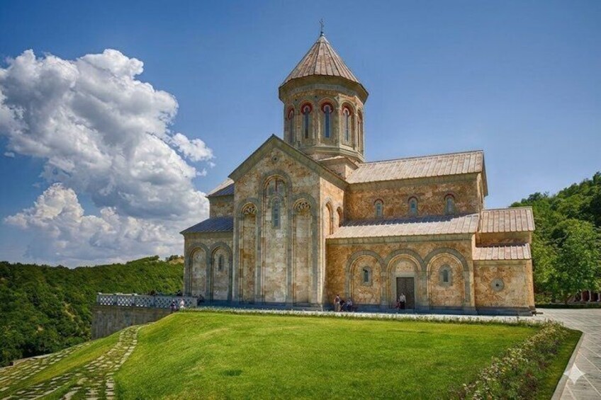 A historic church with a bell tower, surrounded by a well-maintained lawn and a clear sky. 2