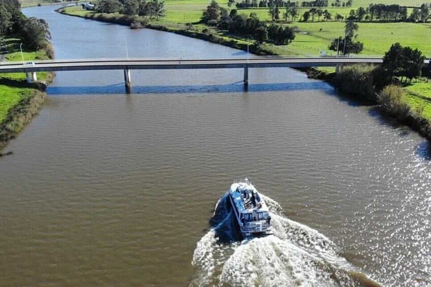 A boat moving on a river with a bridge in the background. 2