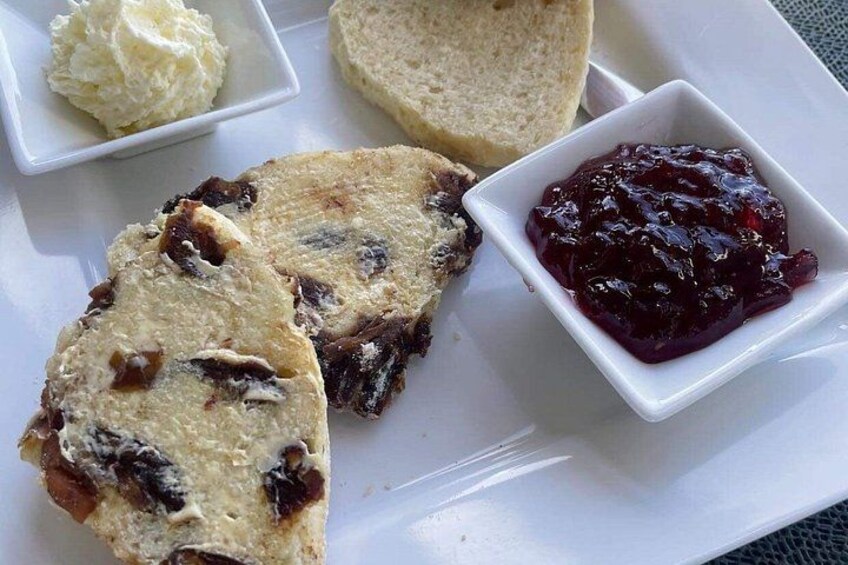A plate with slices of bread, butter, and jam. 1