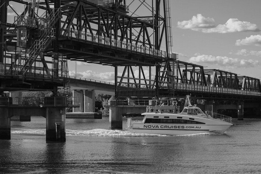 A boat named 'NOVA CRUISES.COM.AU' passing under a bridge. 4
