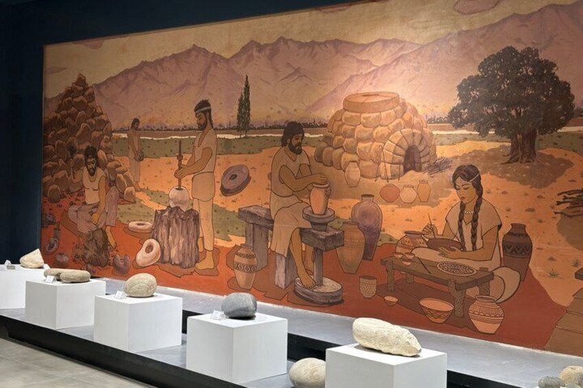 A mural depicting artisans crafting pottery, with a mountainous landscape in the background. 4