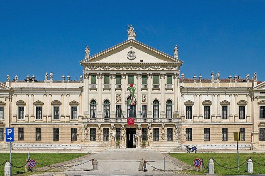 A large classical building with a central entrance, columns, and statues. 5