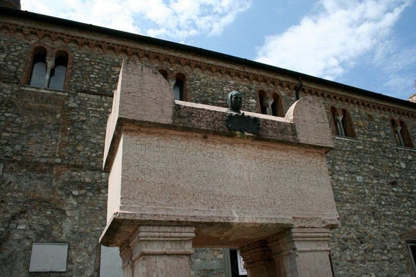 A stone building with arched windows and a large stone archway. 2