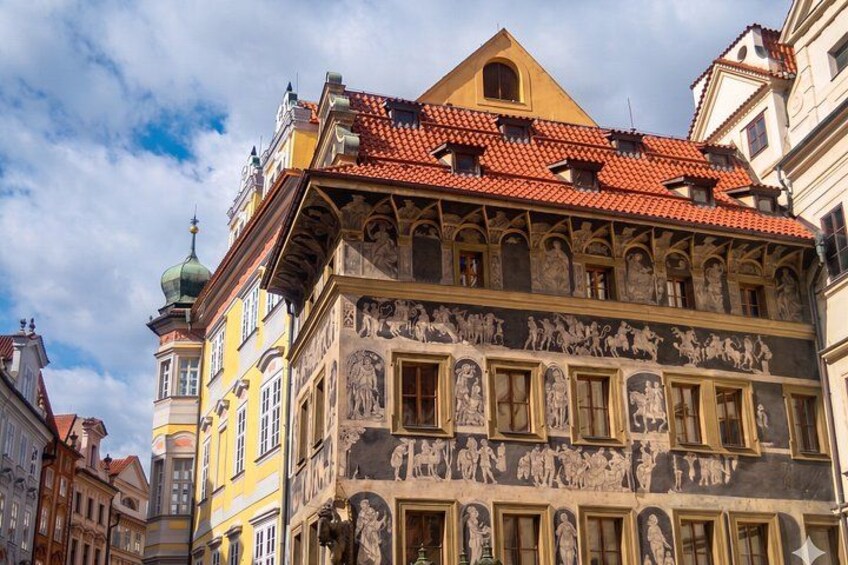 A historic building with a red-tiled roof and detailed frescoes. 2