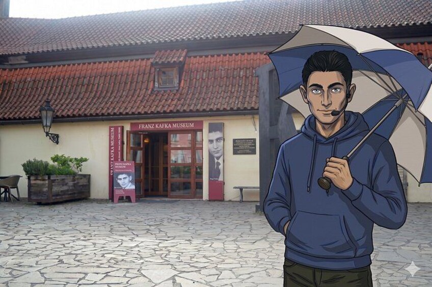 A person standing in front of the Franz Kafka Museum, holding an umbrella. 5