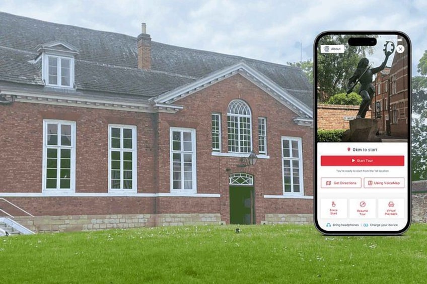 A brick building with a green door and windows, a statue in front, and a smartphone displaying a map. 1