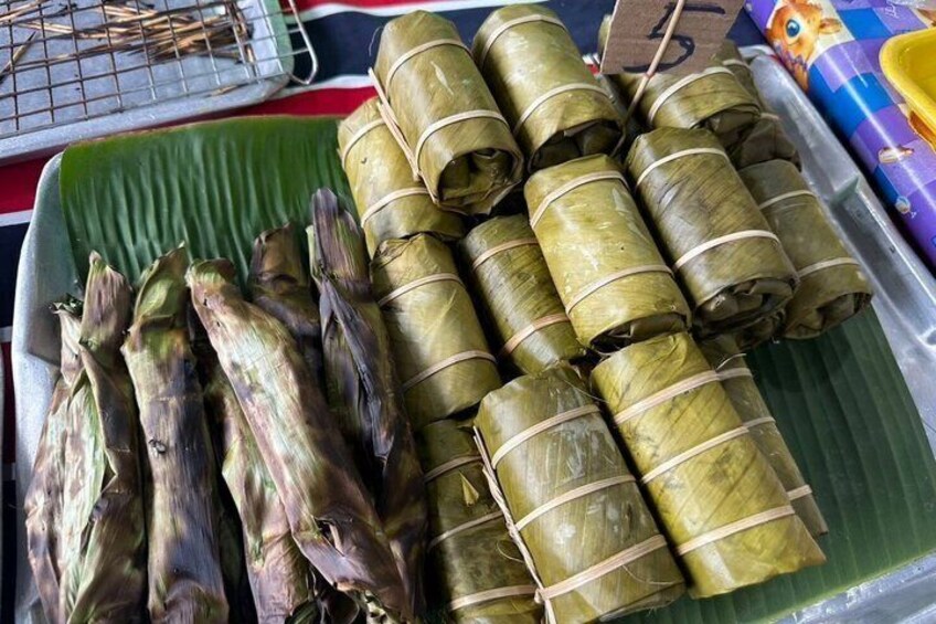 A tray of food wrapped in leaves, possibly a traditional dish. 4