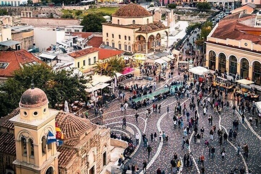 A bustling square with historic buildings, a prominent clock tower, and a central fountain. 4