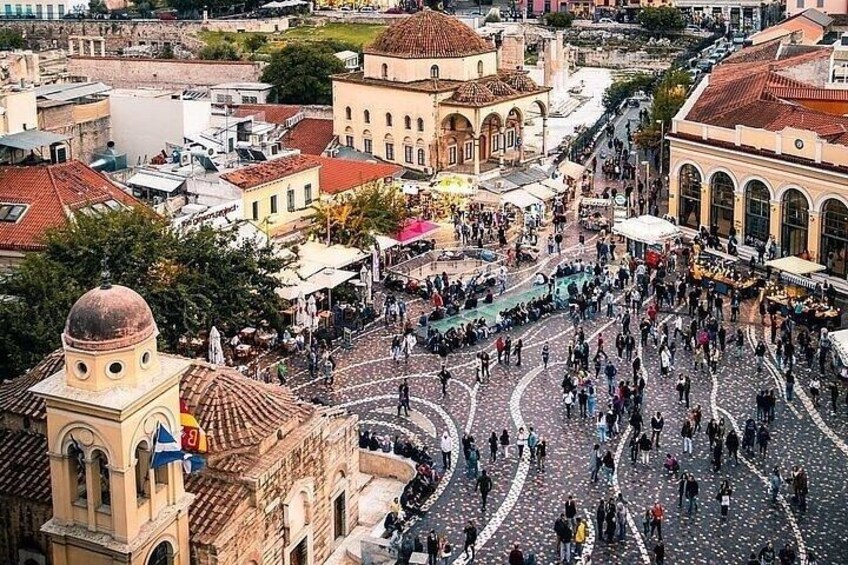 A bustling square with historic buildings, a prominent dome, and a crowd of people. 4