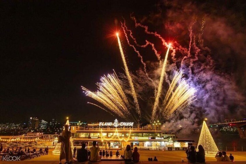A nighttime scene with fireworks display, a Ferris wheel, and a large illuminated building. 3