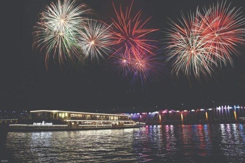 A river with a boat and fireworks in the sky. 2