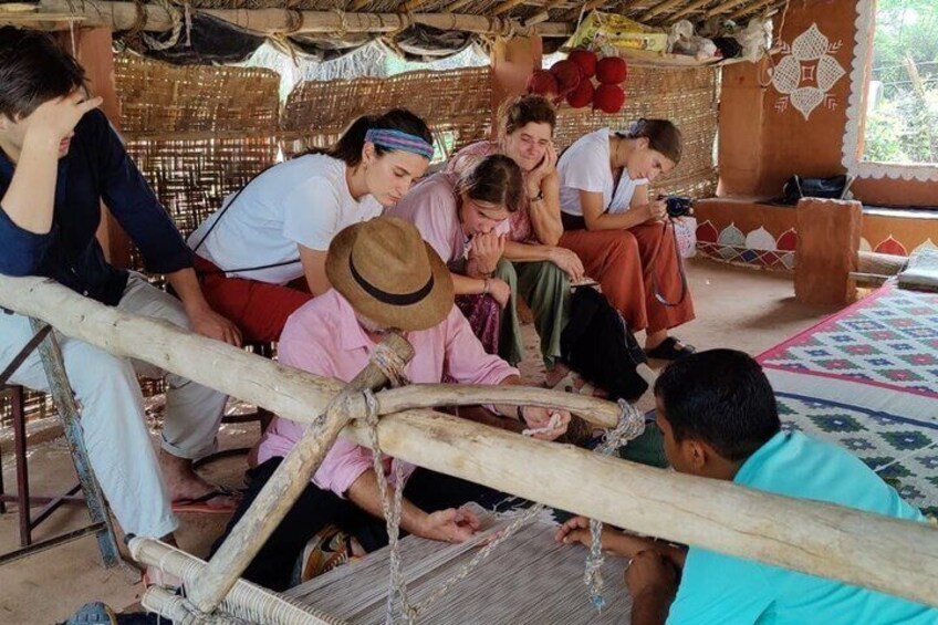 A group of people engaged in weaving with traditional looms. 3