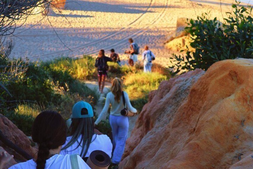 A group of people hiking on a trail surrounded by rocky terrain and vegetation. 5