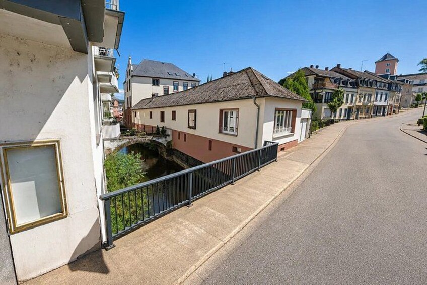 A residential street with houses, a small canal, and a clear blue sky. 5
