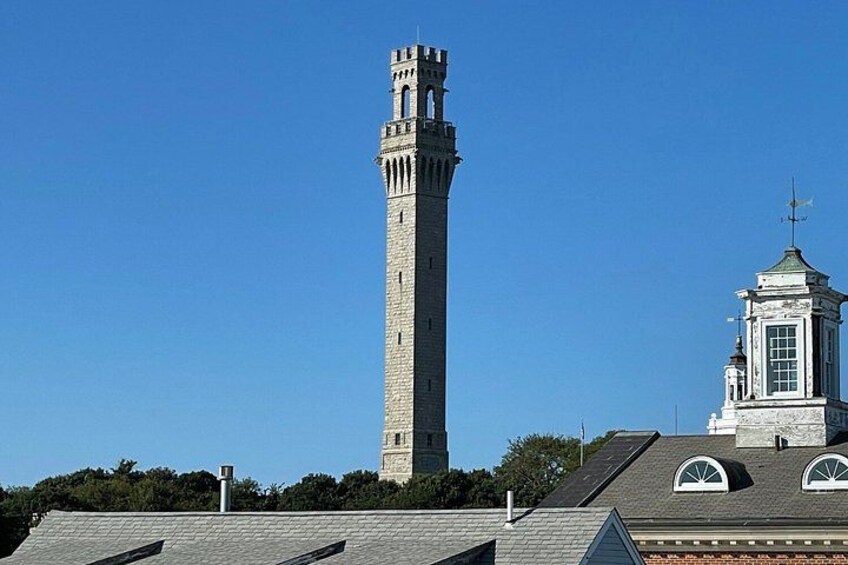 A tall stone tower with a clock tower nearby. 4
