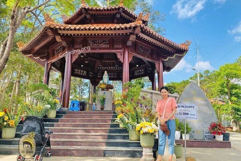 A traditional pavilion with a tiled roof, surrounded by steps and potted plants. 1