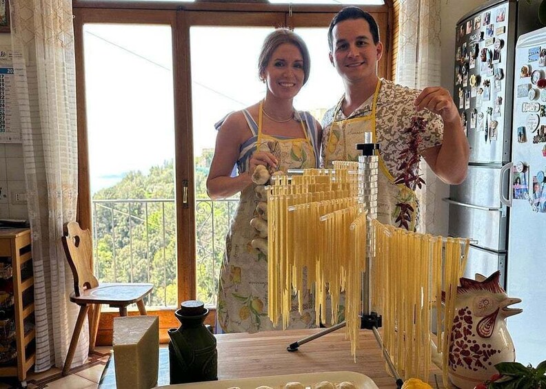 Two people in a kitchen making pasta. 3