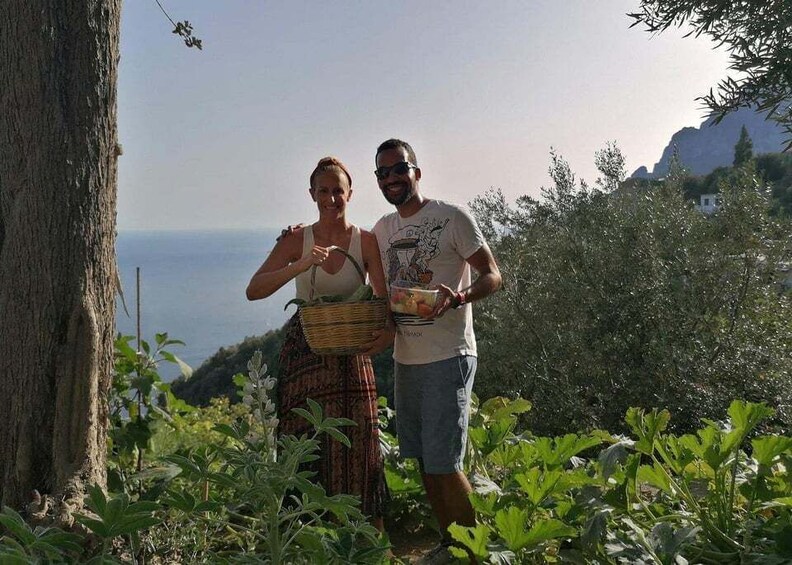 Two people standing in a garden with a view of the sea. 4
