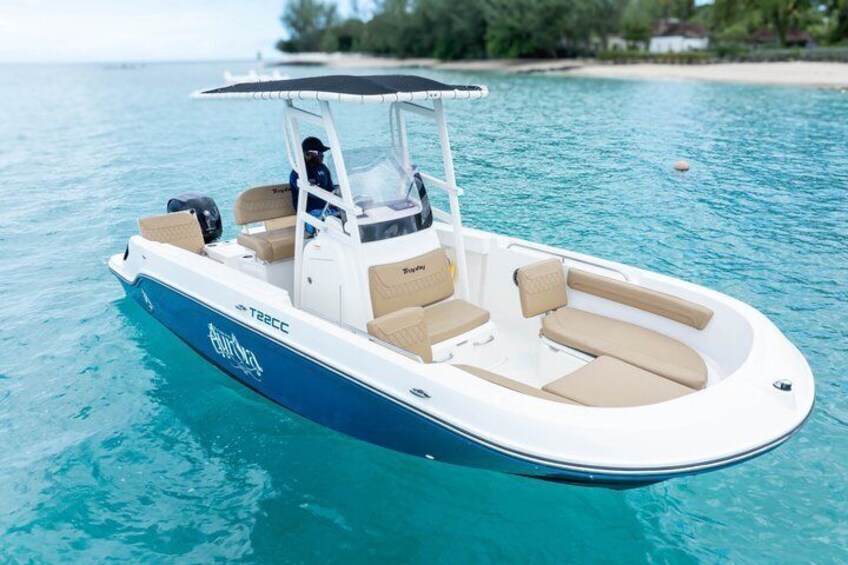 A motorboat with a cabin and seating, floating on clear blue water. 3
