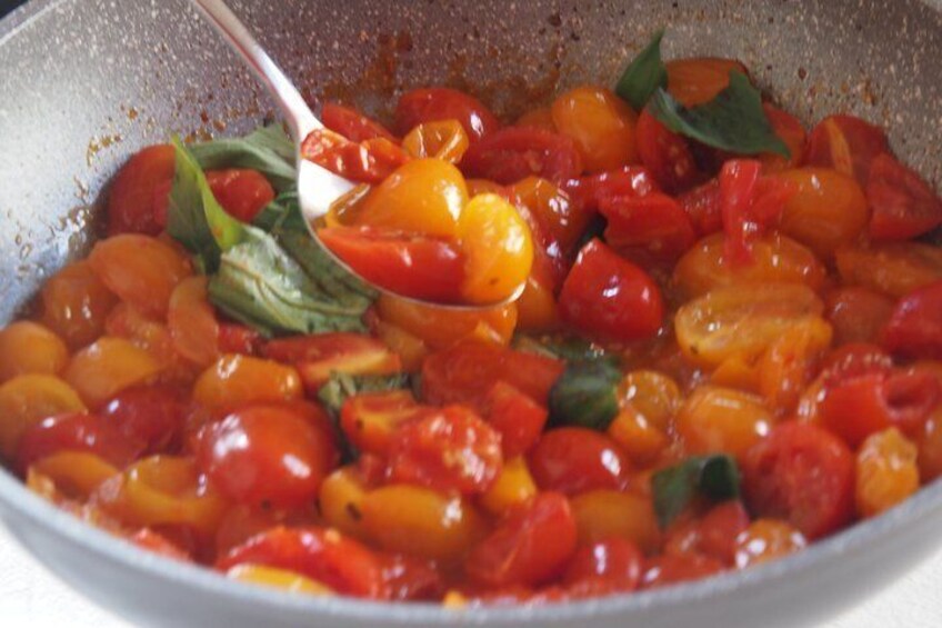A pan with a mixture of cherry tomatoes and basil. 2