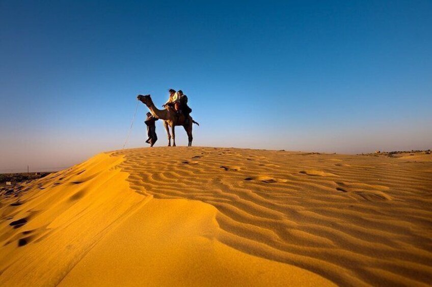 A camel with riders in a desert. 5