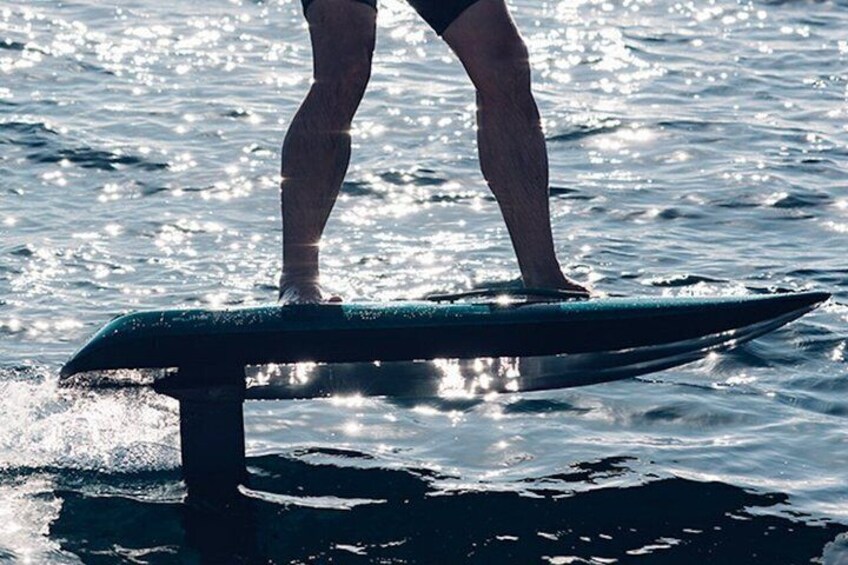 A person standing on a surfboard in the ocean. 5
