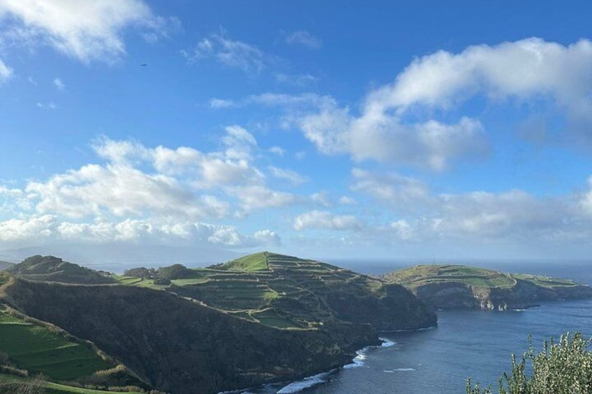A coastal landscape with rolling hills and a clear blue sky. 2