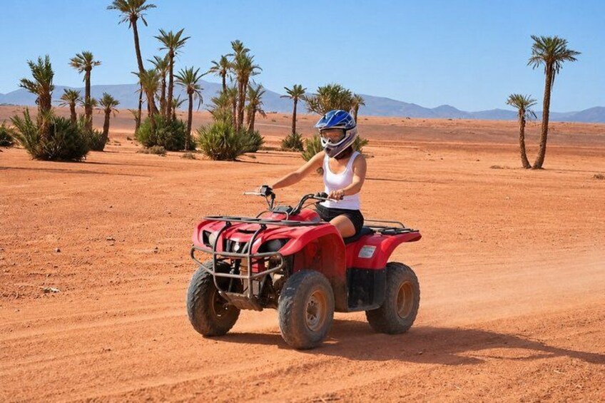 A person riding a red ATV in a desert with palm trees and mountains in the background. 4