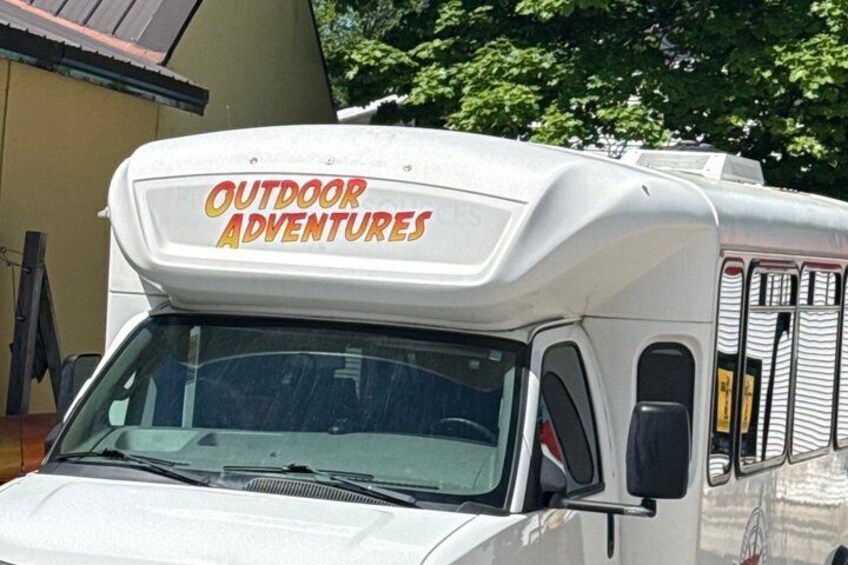 A white RV with 'Outdoor Adventures' written on the front. 2