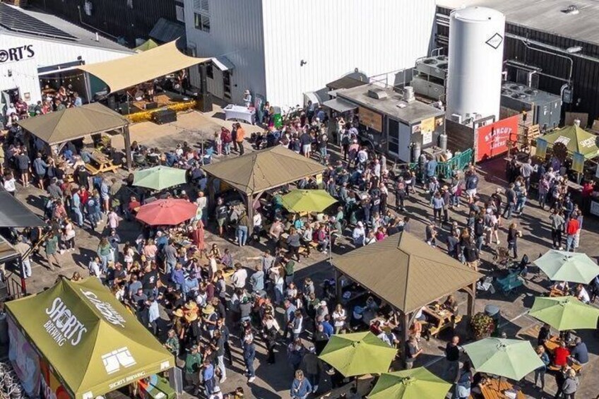 A crowded outdoor market with numerous tents and people. 4