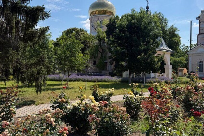 A garden with a large dome structure, surrounded by trees and flowering plants. 4