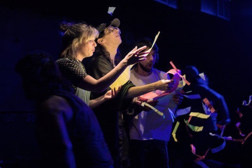 People on a stage with a microphone stand and a person holding a yellow object. 1