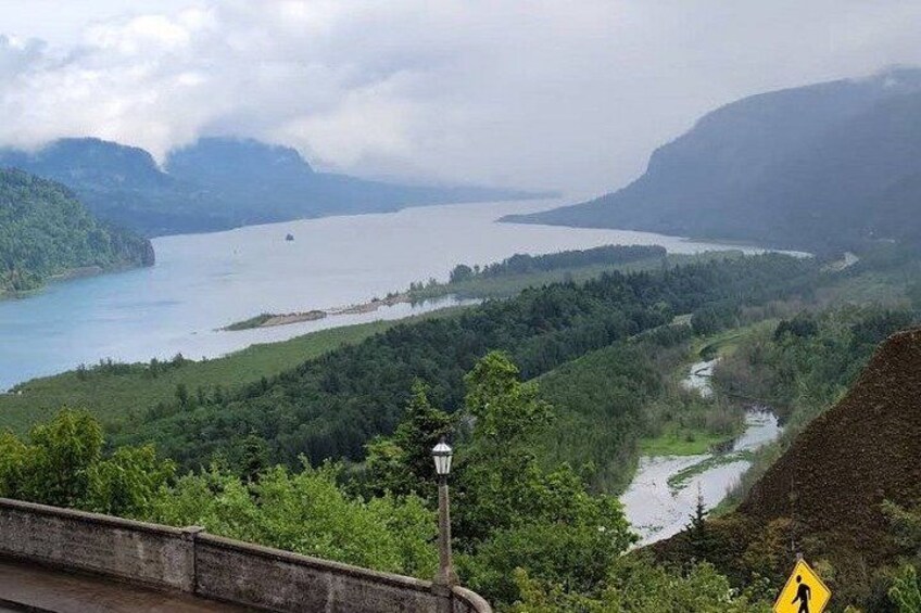 A river winding through a valley with a bridge and a lighthouse in the foreground. 3