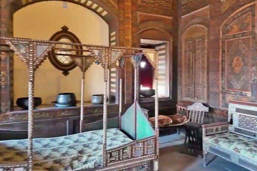 A room with ornate furniture, including a canopy bed and a wooden chest. 5