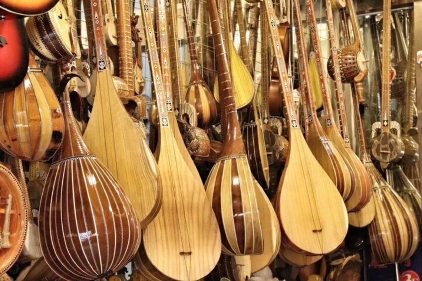 A variety of stringed musical instruments hanging in a shop. 5