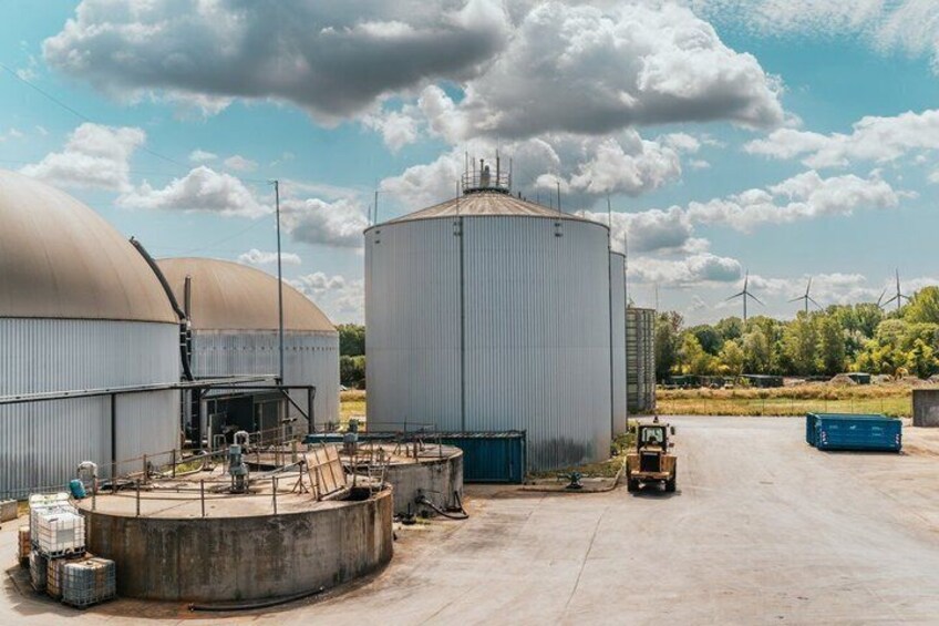 Industrial storage tanks, a forklift, and a clear sky. 3