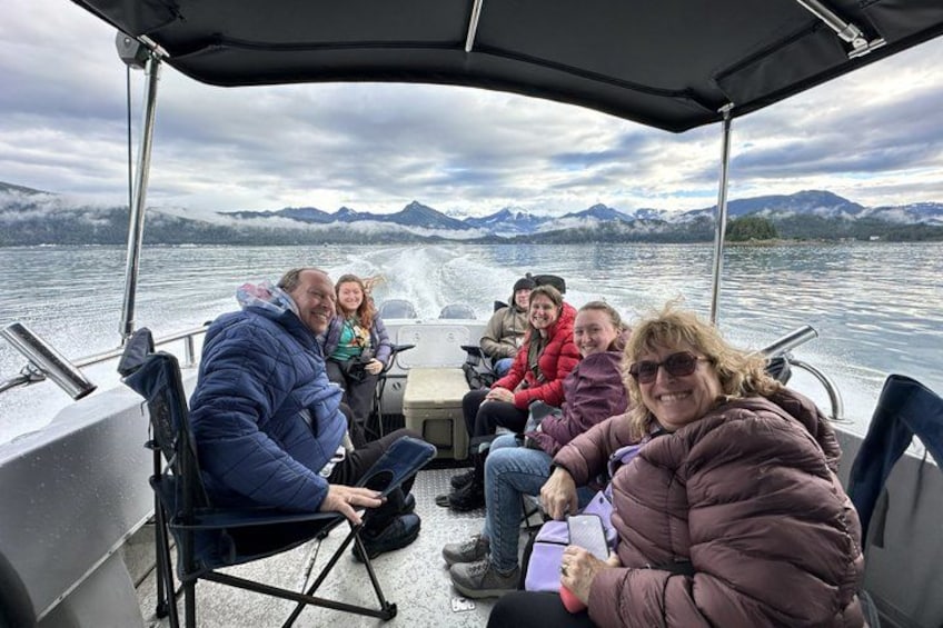 A group of people on a boat with a lake and mountains in the background. 2