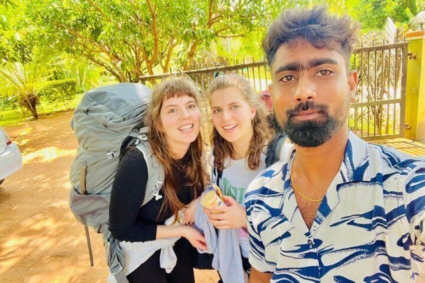 Three people outdoors with greenery and a fence in the background. 3