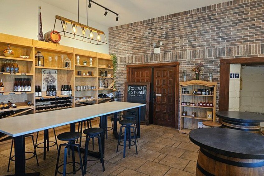 A bar with a long counter, stools, shelves with bottles, and a brick wall. 2