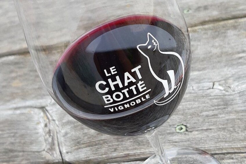 A wine glass with a cat logo and text 'LE CHAT BOTTE VIGNOBLE' on it. 5
