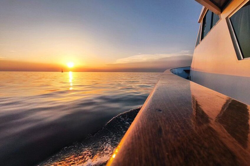 A boat on calm water during sunset with a clear sky. 2