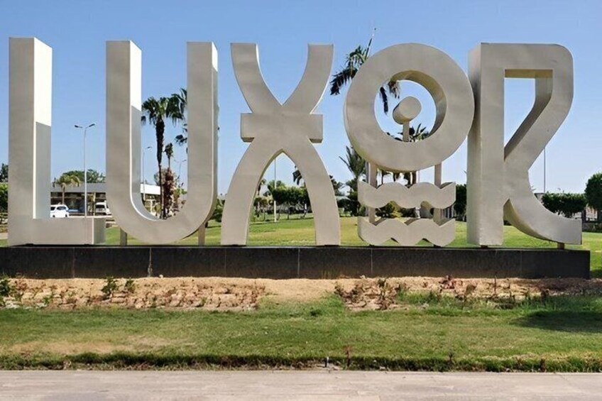 A large, metallic sign with the word 'LUXOR' in capital letters. 1