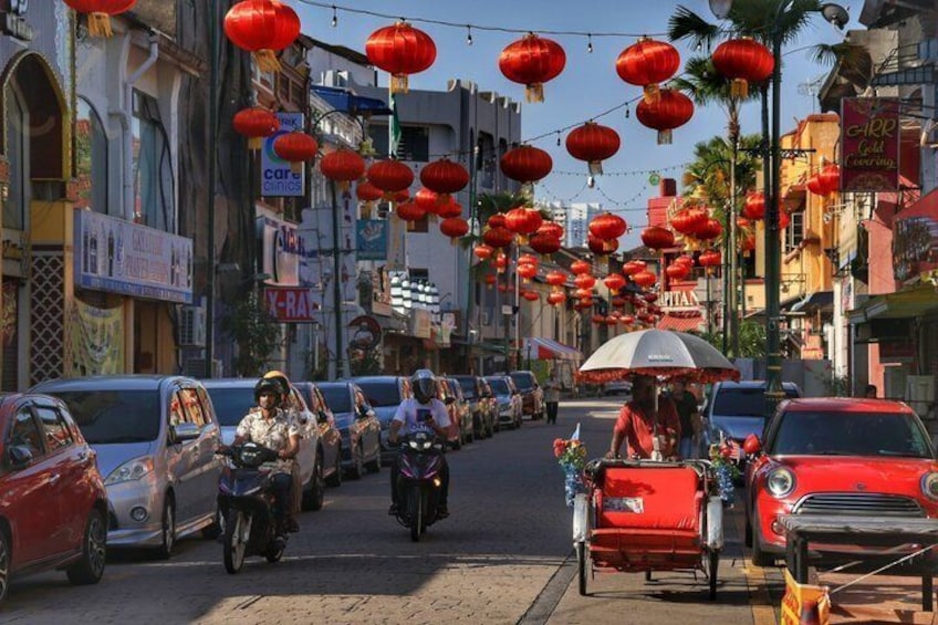 A street lined with red lanterns, cars, and motorbikes. 1