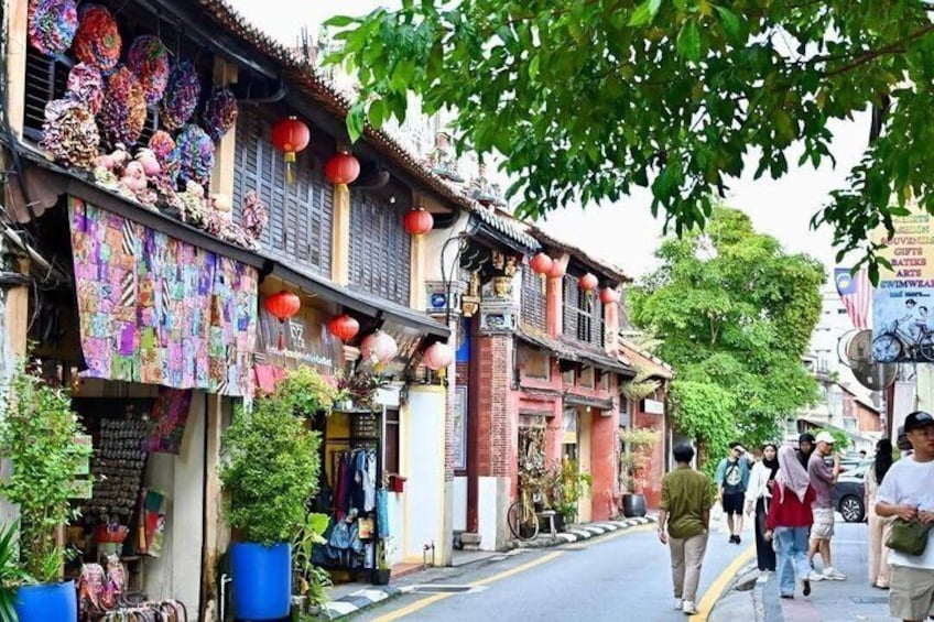 A street with traditional buildings, colorful textiles, and red lanterns. 3
