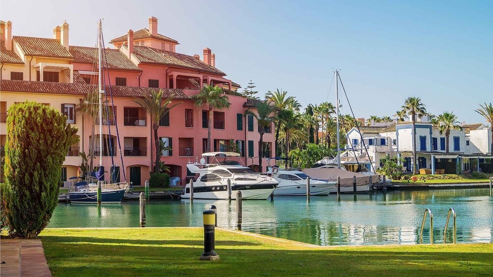 A marina with boats docked, a pool, and buildings with balconies. 4