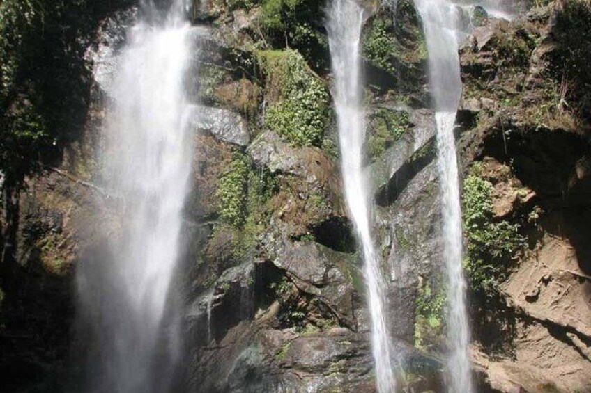 A waterfall cascading over rocky terrain with lush greenery. 3