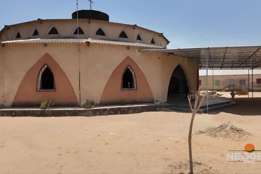 A building with a circular design, arched windows, and a cross on top. 3